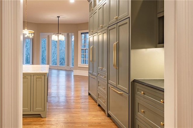 kitchen featuring pendant lighting, glass insert cabinets, baseboards, light wood finished floors, and gray cabinetry