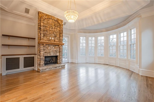 unfurnished living room with crown molding, a chandelier, and light wood-style floors