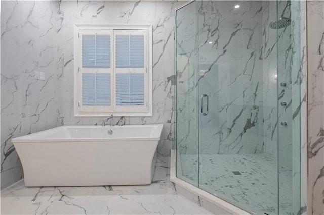 bathroom featuring marble finish floor, a marble finish shower, and a soaking tub