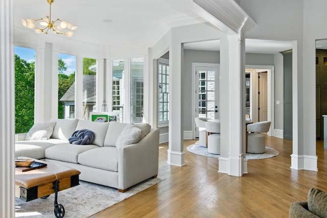 6756 Hedge Row Ln, Gainesville, GA 30506 - living area featuring decorative columns, ornamental molding, light wood-style floors, baseboards, and a chandelier
