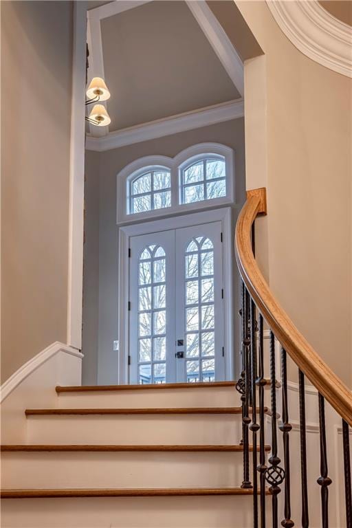 foyer featuring crown molding and stairway