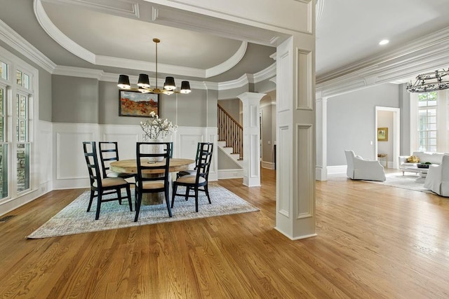 6756 Hedge Row Ln, Gainesville, GA 30506 - dining space with crown molding, a chandelier, decorative columns, wood finished floors, and a decorative wall
