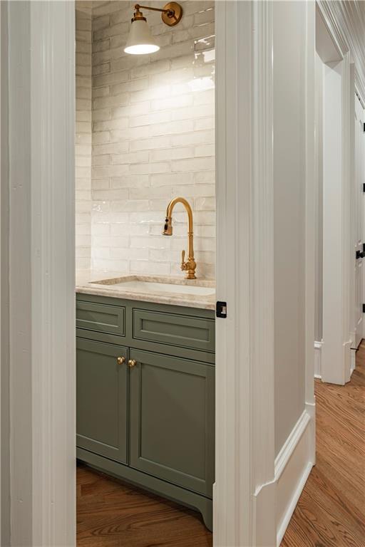 interior space featuring backsplash, a sink, and dark wood-type flooring