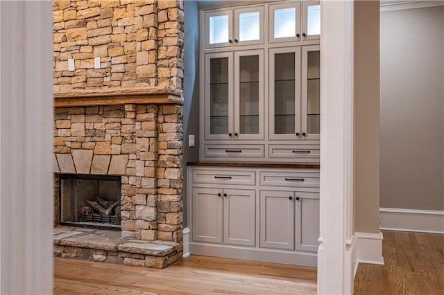 details featuring baseboards, wood finished floors, and a fireplace
