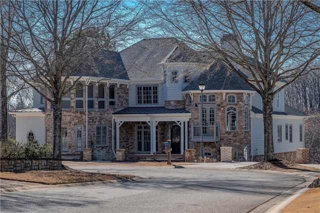 view of front of home with a standing seam roof, metal roof, and stone siding