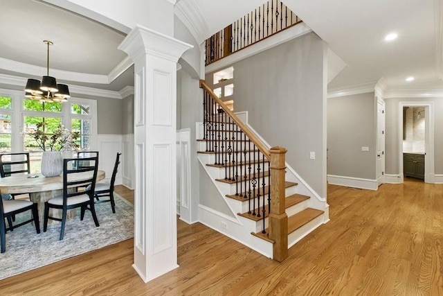 6756 Hedge Row Ln, Gainesville, GA 30506 - stairway featuring a chandelier, crown molding, decorative columns, wood finished floors, and recessed lighting