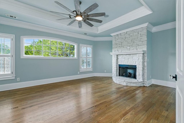 6756 Hedge Row Ln, Gainesville, GA 30506 - unfurnished living room featuring a tray ceiling, crown molding, a ceiling fan, plenty of natural light, and a stone fireplace