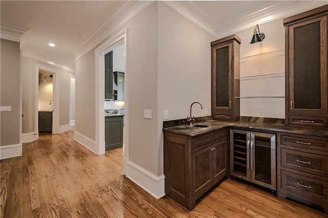 bar featuring crown molding, beverage cooler, and light wood finished floors