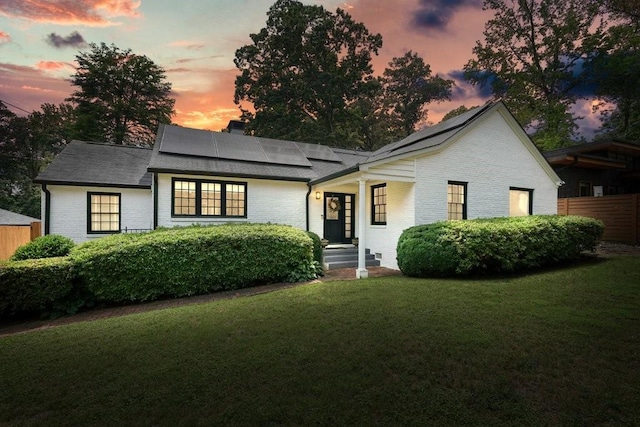 3734 Powers Ferry Rd NW, Atlanta, GA 30342 - view of front of home with a front lawn, solar panels, brick siding, and a chimney