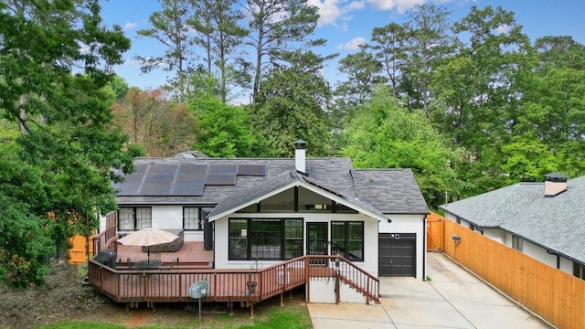 3734 Powers Ferry Rd NW, Atlanta, GA 30342 - rear view of property featuring a shingled roof, driveway, solar panels, a deck, and a garage