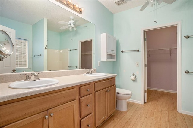 bathroom featuring ceiling fan, vanity, toilet, and hardwood / wood-style floors