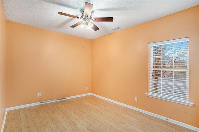 empty room with hardwood / wood-style floors, a textured ceiling, and ceiling fan