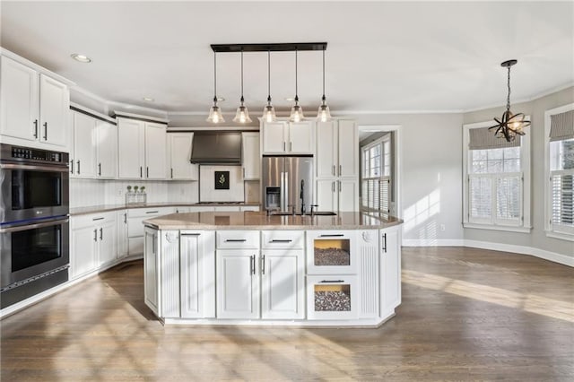 kitchen featuring decorative light fixtures, a center island, white cabinets, and appliances with stainless steel finishes