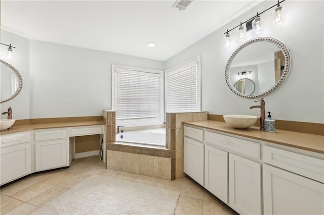 bathroom with vanity, tile patterned flooring, and tiled tub