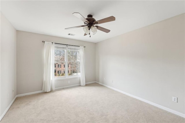 spare room with ceiling fan and light colored carpet