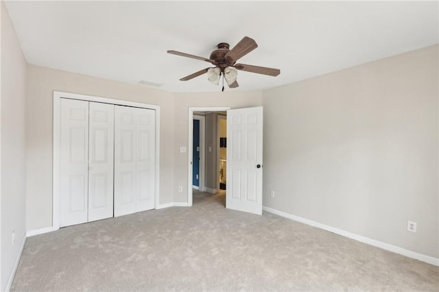 unfurnished bedroom featuring light carpet, ceiling fan, and a closet