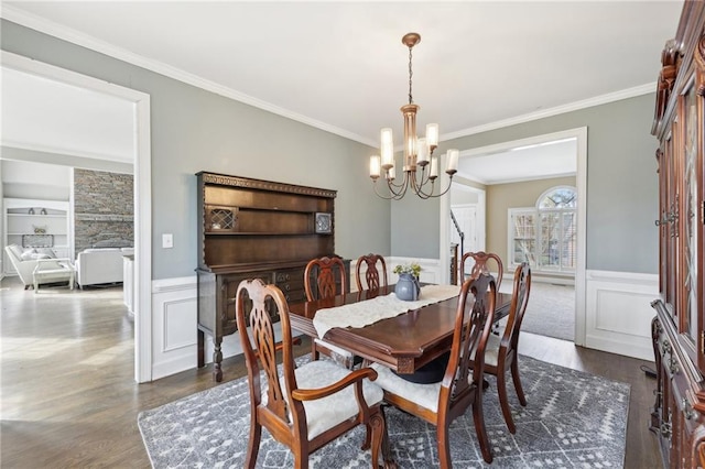 dining space with an inviting chandelier, dark wood-type flooring, and ornamental molding