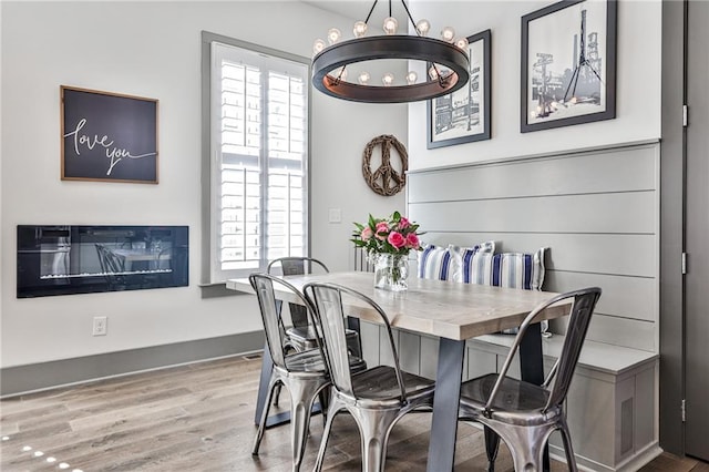 dining space featuring a healthy amount of sunlight, an inviting chandelier, and wood finished floors