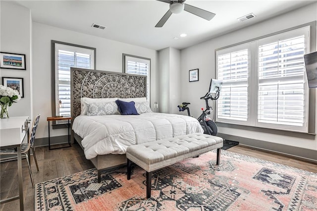 bedroom featuring a ceiling fan, baseboards, visible vents, and wood finished floors