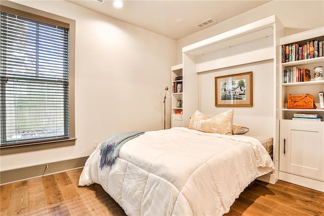 bedroom featuring visible vents and wood finished floors