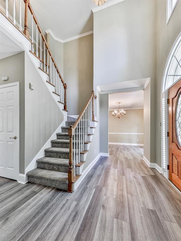 4601 Ethel Springs Trl SW, Mableton, GA 30126 - entrance foyer with a chandelier, stairs, wood finished floors, a towering ceiling, and baseboards