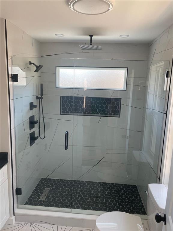 bathroom featuring an enclosed shower, vanity, toilet, and plenty of natural light