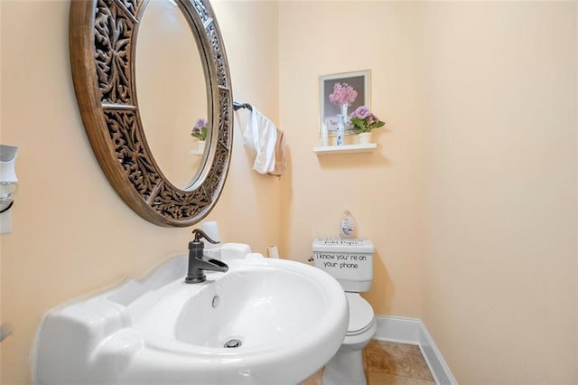 bathroom featuring tile patterned flooring, toilet, and baseboards