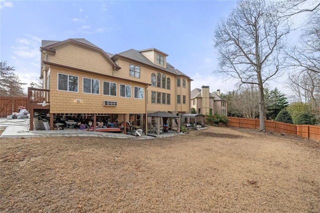 rear view of house featuring a patio, a gazebo, and a fenced backyard