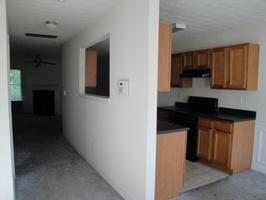 kitchen with black stove and exhaust hood