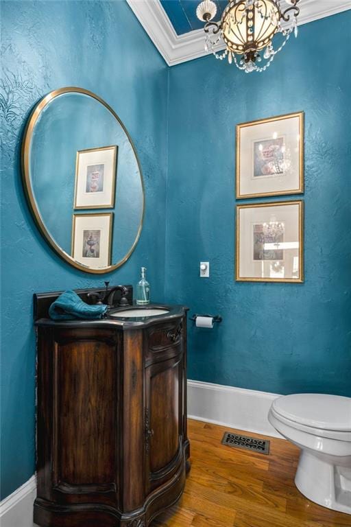 bathroom featuring vanity, visible vents, an inviting chandelier, ornamental molding, and toilet