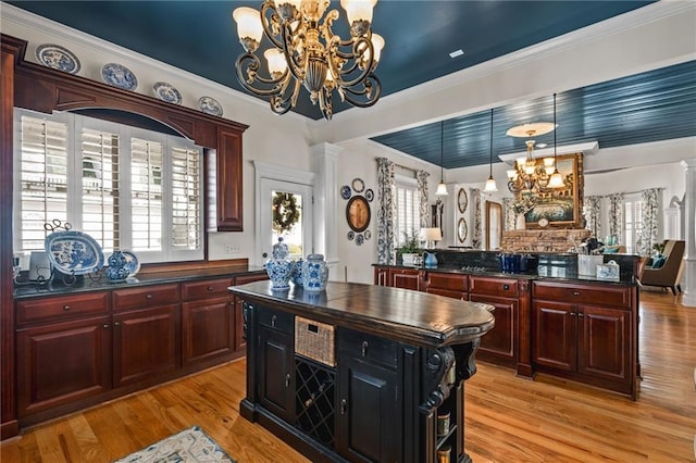 kitchen featuring dark countertops, a notable chandelier, reddish brown cabinets, and a kitchen island