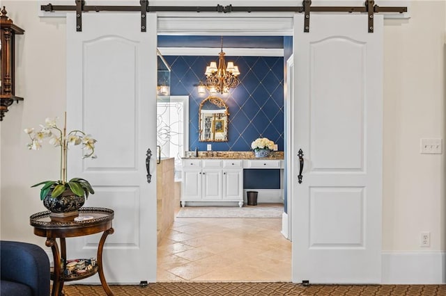 bar featuring decorative light fixtures, an inviting chandelier, and a barn door