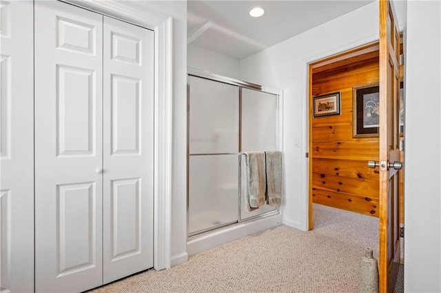 bathroom with a shower with door, recessed lighting, baseboards, and carpet floors