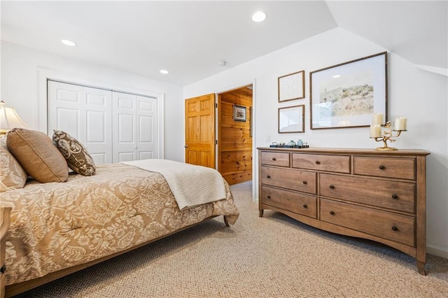 bedroom with vaulted ceiling, recessed lighting, a closet, and light carpet