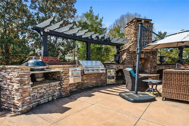 view of patio featuring a stone fireplace, grilling area, a pergola, and an outdoor kitchen