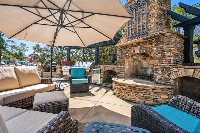 view of patio / terrace with an outdoor living space with a fireplace and area for grilling