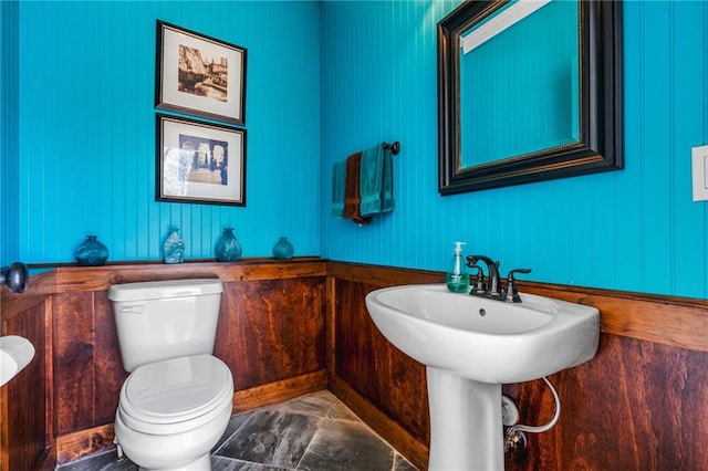 bathroom with toilet and marble finish floor