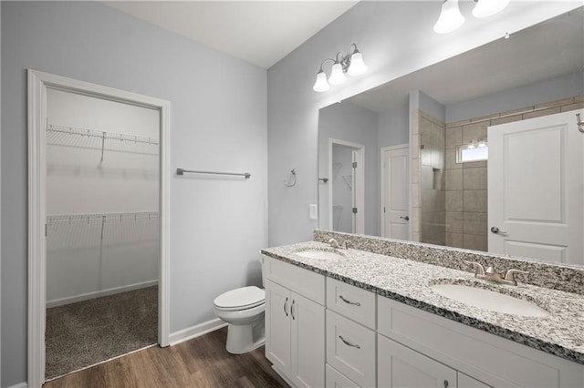 526 Wilbanks Rd, Alto, GA 30510 - bathroom featuring wood finished floors, a sink, a walk in closet, double vanity, and toilet