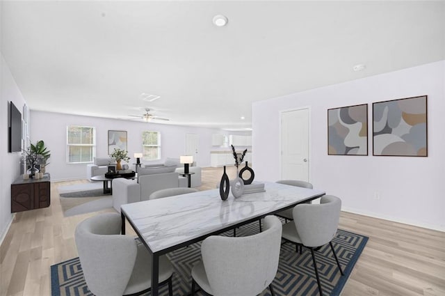 dining area with ceiling fan and light wood-type flooring