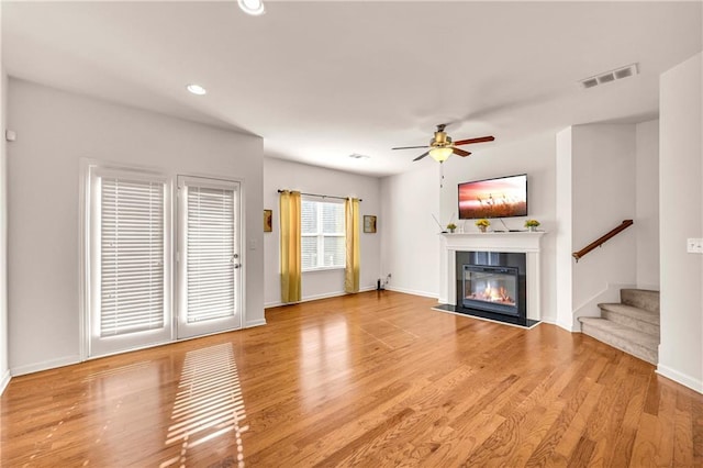 unfurnished living room with ceiling fan and wood-type flooring