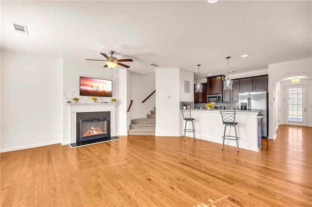 unfurnished living room with ceiling fan and light hardwood / wood-style flooring