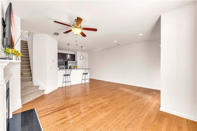 unfurnished living room with ceiling fan and light hardwood / wood-style floors