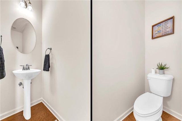 bathroom featuring toilet, sink, and hardwood / wood-style floors