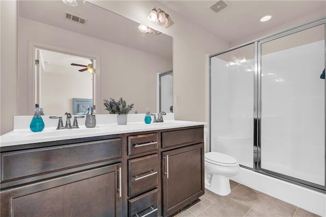 bathroom with ceiling fan, vanity, toilet, tile patterned flooring, and an enclosed shower