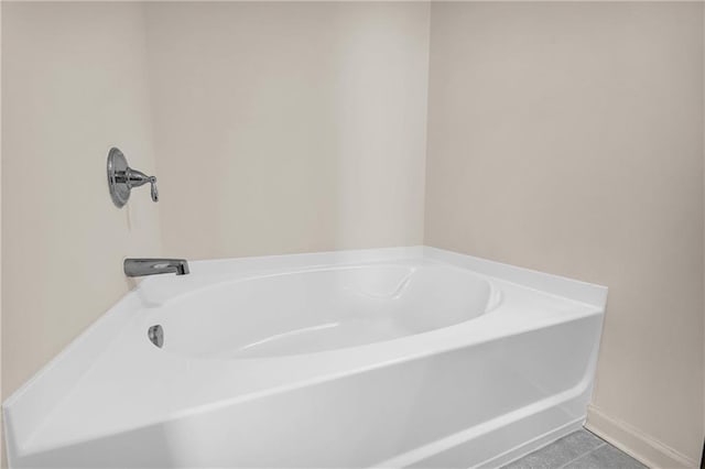 bathroom with tile patterned floors and a bath