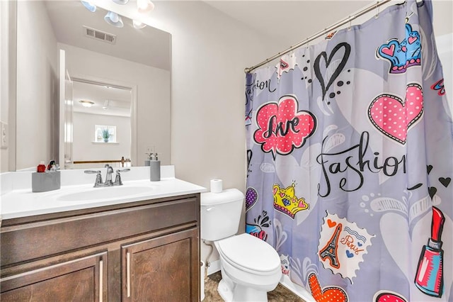 bathroom featuring toilet, vanity, and walk in shower