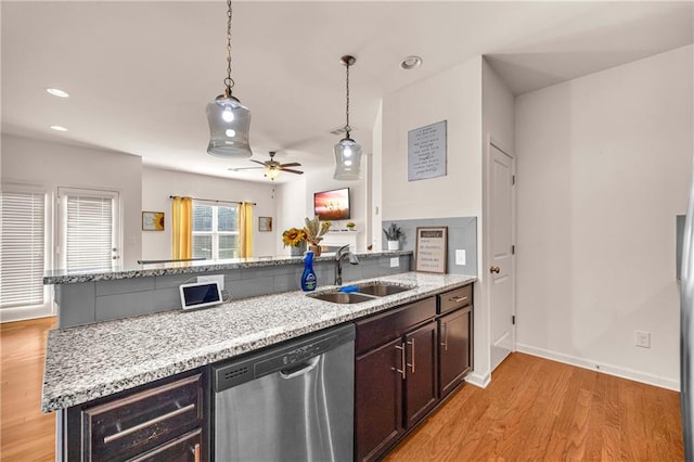 kitchen featuring sink, hanging light fixtures, a kitchen island with sink, ceiling fan, and stainless steel dishwasher