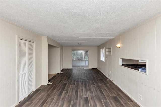 unfurnished living room featuring a textured ceiling and wood finished floors