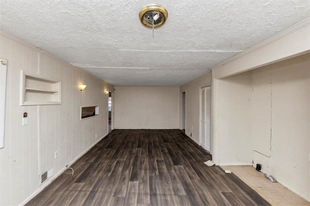 corridor with a textured ceiling, wood finished floors, and visible vents