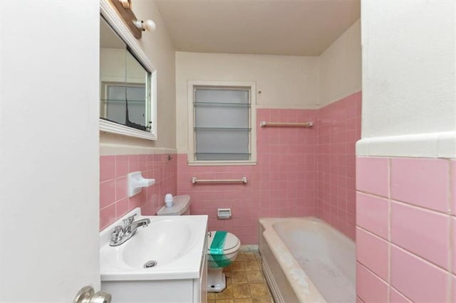 full bath featuring toilet, a wainscoted wall, tile walls, and vanity